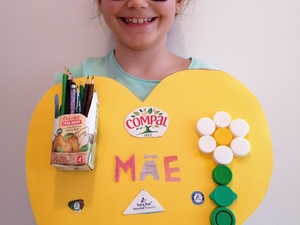 Produto final, quadro com porta lápis para a mãe, apresentado pela autora. É visível o selo da Tetra Pak, o símbolo FSC e que as embalagens utilizadas são da marca Compal.