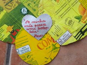 As crianças recortaram corações pequenos com as embalagens de sumo e escreveram mensagens sobre as mães.