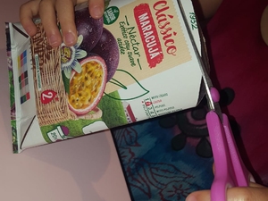 Criança a recortar as embalagens em corações