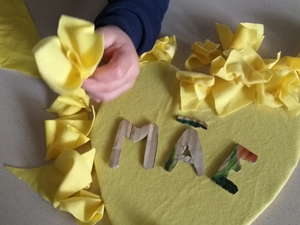 Fizemos pequenos recortes em tecido usado amarelo e com eles elaboramos flores para forramos o coração.