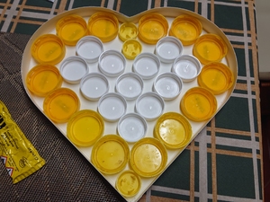 Materiais utilizados, exclusivamente resíduos. Embalagens de compal e caixa de chocolates.Pormenor das tampas.