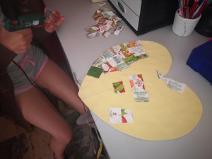 Colagem dos pedaços (quadrados/retângulos) de embalagens da Compal no coração amarelo também com cola quente, aplicando a técnica do mosaico.